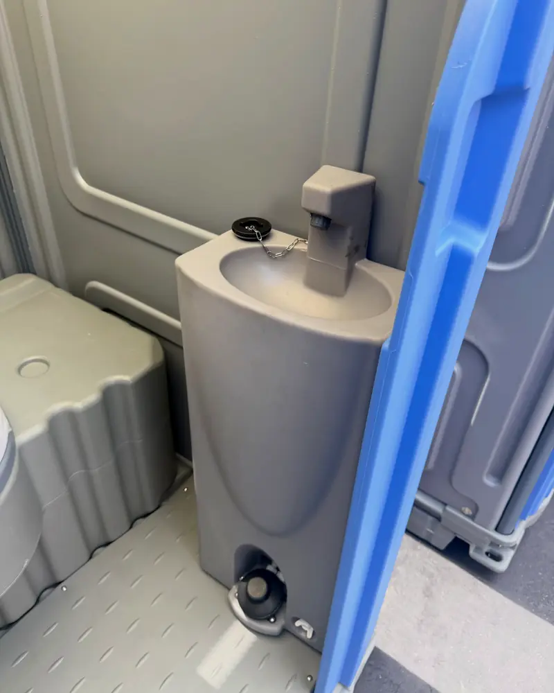 Foot-pump sink with soap inside a deluxe porta potty
