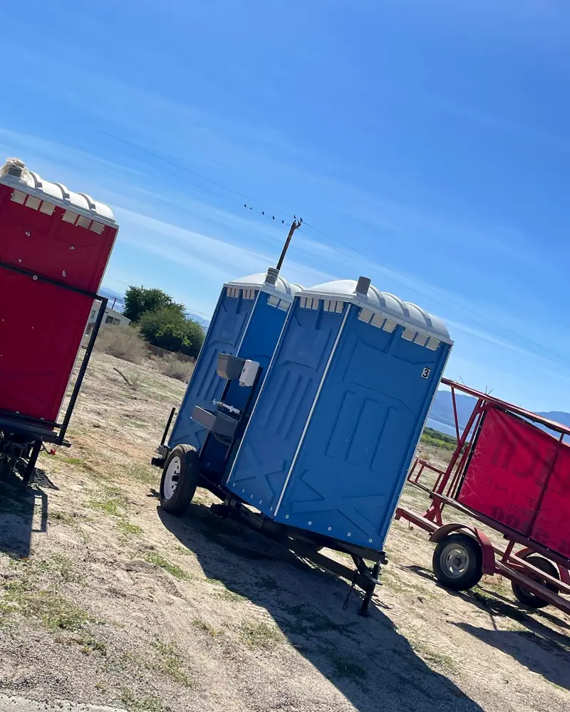 Towable porta potty trailers on a dirt lot