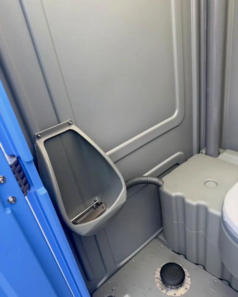 Built-in urinal next to the seat inside a porta potty