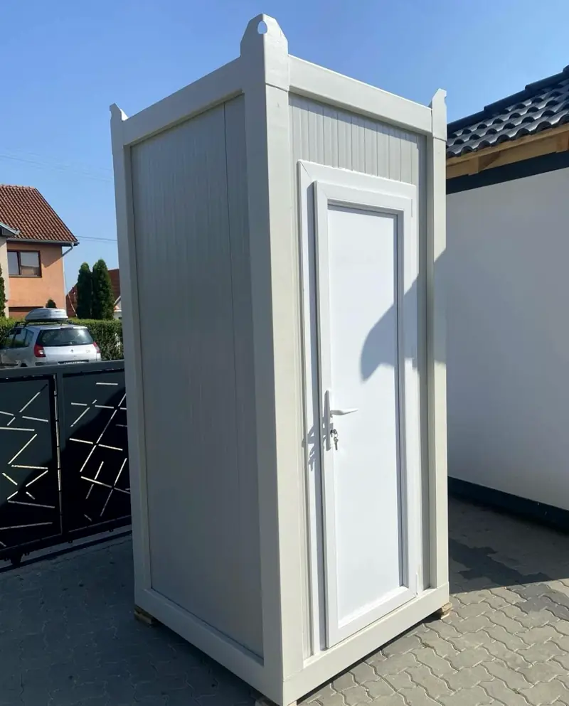White portable restroom cabin parked on a residential driveway