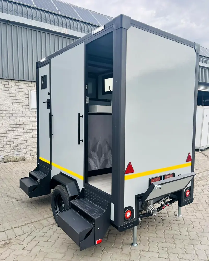 Restroom trailer with a stall door open and hitch jack lowered