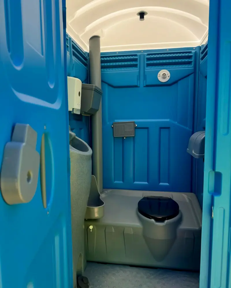 Standard porta potty interior with seat, urinal and toilet paper holder