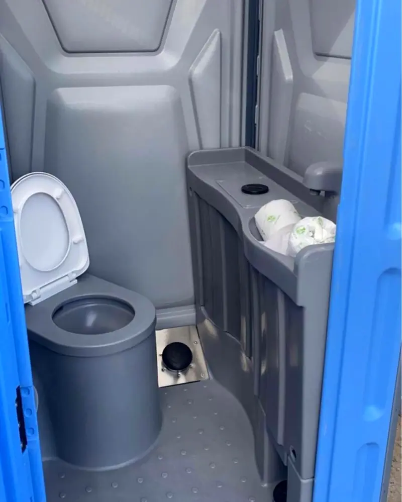 Standard unit interior with toilet seat and spare toilet paper rolls